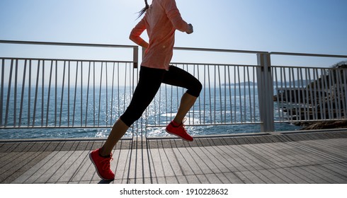 Healthy lifestyle fitness sports woman runner running on seaside trail - Shutterstock ID 1910228632