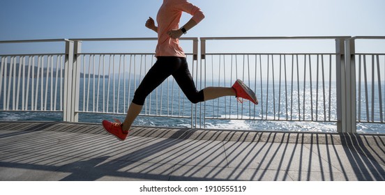 Healthy lifestyle fitness sports woman runner running on seaside trail - Shutterstock ID 1910555119