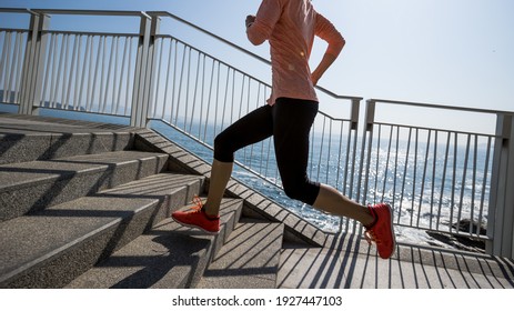 Healthy lifestyle fitness sports woman runner running up stairs on seaside trail
