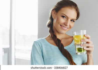 Healthy Lifestyle, Food. Happy Woman Drinking Summer Refreshing Fruit Flavored Infused Water With Fresh Organic Lemon, Lime, Mint. Detox Vitamin-fortified Water. Healthy Eating. Diet Concept. 