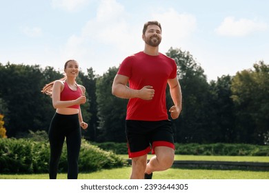 Healthy lifestyle. Happy couple running outdoors on sunny day, low angle view - Powered by Shutterstock