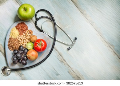 Healthy lifestyle and healthcare concept with food, heart and stethoscope