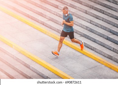 healthy lifestyle middle aged man runner running upstairs on city stairs. Motion shot.