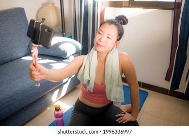 Healthy Lifestyle Portrait Of Young Happy And Beautiful Asian Korean Woman Smiling Sweaty Taking Selfie With Hand Phone After Training Workout On Yoga Mat Following Online Lesson