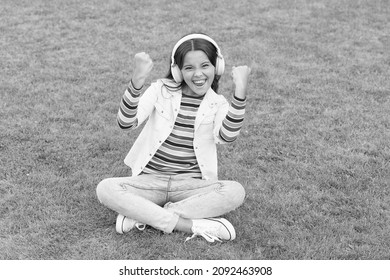 Healthy Lifestyle And Relax. Yoga Girl. Small Kid In Headphones. Summer Playlist. Enjoy Spring Nature Outdoor. Child Study Audio Book. New Technology. Child Listen Music On Green Grass