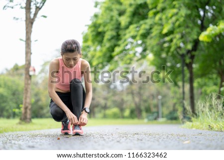 Healthy lifestyle and sport concepts, Fitness sport woman runner jogging ,girl runner jogging exercise benefit workout in a Park, tying laces of running shoes before training.