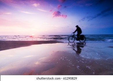 Healthy Lifestyle, Sport. Riding A Bike On The Beach At Sunset