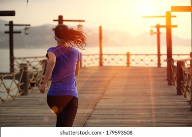 healthy lifestyle sports woman running on wooden pier 
