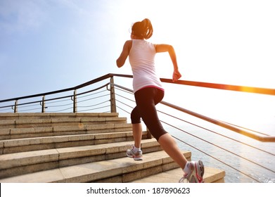 healthy lifestyle sports woman running on stone stairs seaside 