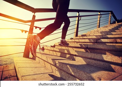healthy lifestyle sports woman running up on stone stairs at sunrise seaside  - Shutterstock ID 255732652