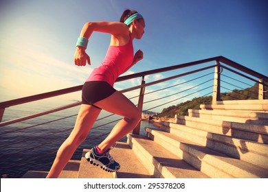 Healthy lifestyle sports woman running up on stone stairs seaside