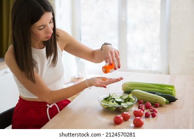 Healthy Lifestyle. Supporting Immune System. Woman Takes Vitamins. Vitamin Supplements For Beauty, Skin, Hair, With Green Vegan Food. At Lunch At Home