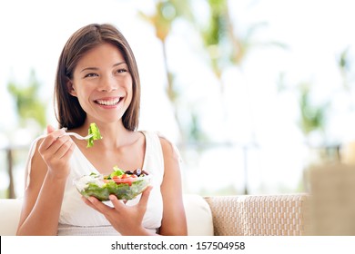 Healthy Lifestyle Woman Eating Salad Smiling Happy Outdoors On Beautiful Day. Young Female Eating Healthy Food Outside In Summer Dress Laughing And Relaxing In Sofa. Pretty Multiracial Model.