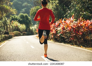 Healthy lifestyle woman runner stretching legs in morning park - Shutterstock ID 2241408387