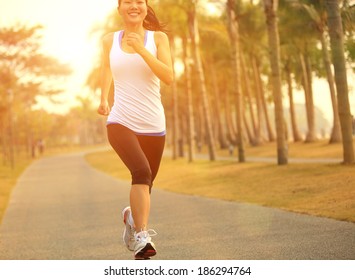 healthy lifestyle young asian sporty woman jogging at tropical park 