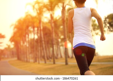 healthy lifestyle young asian sporty woman jogging at tropical park 