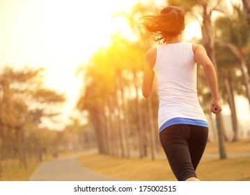 Healthy lifestyle young sporty asian woman running at tropical park