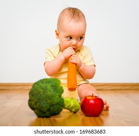 Healthy Living. Baby Eating Fruit And Vegetables - Sitting On Floor