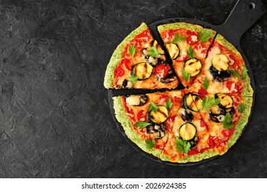 Healthy, Low Carb Broccoli Crust Pizza With Tomatoes, Zucchini And Mushrooms. Overhead View With Cut Slices On A Dark Slate Background.