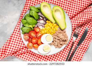 Healthy lunch bowl: egg, tuna, avocado, cherry tomatoes, corn salad, onion - Powered by Shutterstock