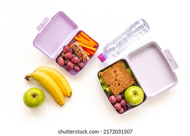 Healthy lunch boxes filled with fruits and vegetables, top view