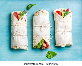 Healthy Lunch Snack. Tortilla Wraps With Grilled Chicken Fillet And Fresh Vegetables On Blue Painted Wooden Background. Top View