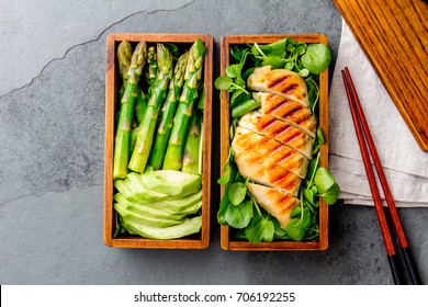 Healthy Lunch In Wooden Japanese Bento Box. Balanced Healthy Food Grilled Chucken And Avocado With Asparagus And Green Salad. Top View, Slate Gray Background.