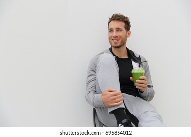 Healthy Man Drinking Green Smoothie Post Workout At Gym. Sport Athlete With Spinach Cold Pressed Juice Plastic Cup Drink Relaxing On White Background.