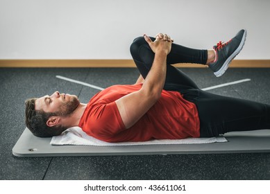 healthy man stretching leg before gym workout. Fitness strong male athlete. Male young fit exercising.