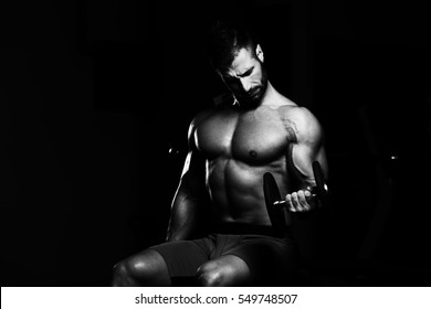 Healthy Man Working Out Biceps In A Dark Gym - Dumbbell Concentration Curls - Shutterstock ID 549748507