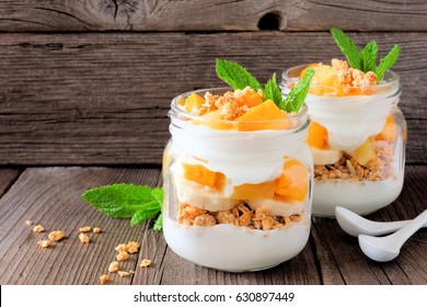 Healthy mango and pineapple parfaits in mason jars with a rustic wood background - Powered by Shutterstock