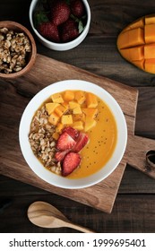 Healthy Mango Smoothie Bowl With Strawberry And Granola. Above View Scene On Wooden Table. 