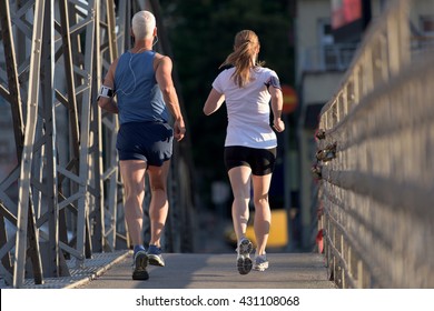 healthy mature couple jogging in the city  at early morning with sunrise in background - Shutterstock ID 431108068