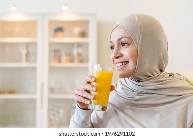 Healthy Mature Muslim Islamic Arabian Woman In Hijab Drinking Fresh Orange Juice Smoozie , Feeling Energy Flow. Healthy Eating Breakfast, Vitamins And Organic Nutrition