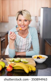 Healthy Mature Woman Eating Fruit Salad At Home