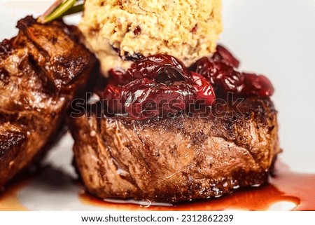A healthy meal of beef medallions with a side of dried tomatoes served on a plate.
