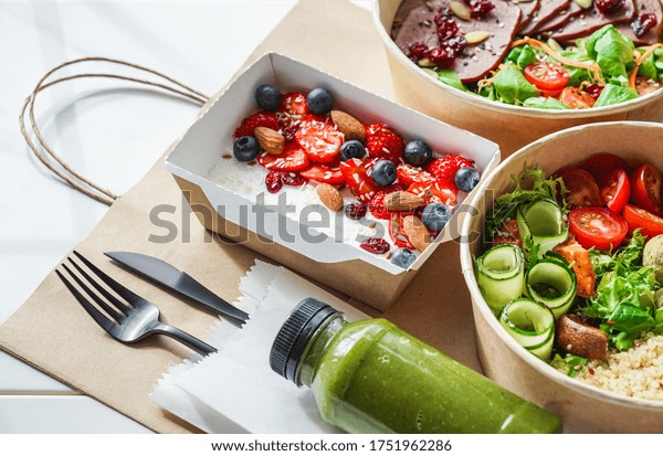 Healthy meal slimming diet plan daily ready menu
background, organic fresh dishes and smoothie, fork knife on paper
eco bag as food delivery courier service at home in office concept,
close up view.