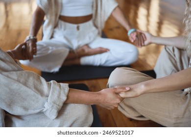 Healthy mindful women group sitting in circle meditating together holding hands doing yoga breathing exercises giving support during body health retreat holistic healing training session. Close up. - Powered by Shutterstock