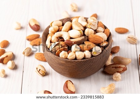 Healthy mix nuts on wooden background. Almonds, hazelnuts, cashews, peanuts, pistachios, Brazilian nuts