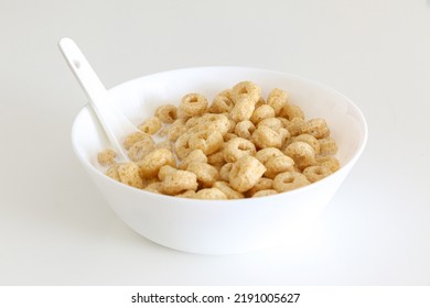 Healthy Morning Oat Cereal, Cheerios In Bowl Of Milk With Spoon, Low Sugar And High Fibre Breakfast, Isolated On White Background