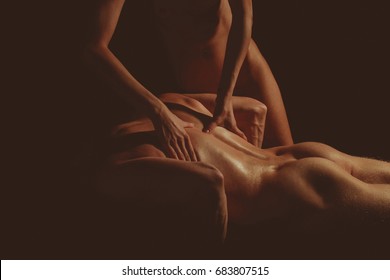 Healthy muscular young man. Beautiful athletic woman shakes her abdominal muscles on dark background. Sexy couple. Massage couple. Erotic fashion photo. Sexual concept. Sexy man ass. Strong body.