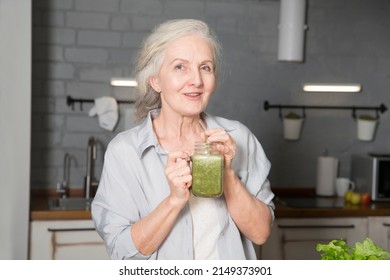 Healthy nutrition in the family, vegetarianism. Senior lifestyle. elderly woman n drink smoothie from greenery and superfoods in the kitchen at home - Powered by Shutterstock