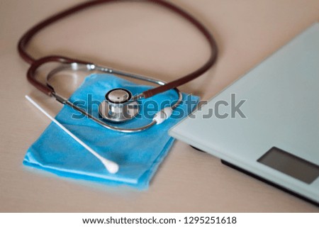 
Healthy nutrition, medicine, health care, nutritional supplements and weight loss concept. stethoscope on the table and white scales. 
Selective focus