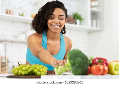 Healthy Nutrition And Wellness Concept. Happy Black Lady Cooking Dinner With Fresh Organic Vegetables To Improve Health And Immune System, Copy Space. Woman Preparing At Kitchen At Home