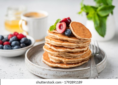 Healthy oat pancakes with berries on a craft ceramic plate. Vegan breakfast food - Powered by Shutterstock