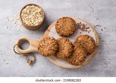 Healthy Oatmeal Cookies With Dates, Nuts And Flaxseed On A Wooden Board On A Gray Textured Background, Top View. Delicious Homemade Vegan Food