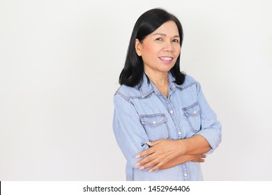 Healthy Old Asian Woman In Jeans Shirt Standing Fold Arm And Smiling  With Happiness. White Background With Copy Space