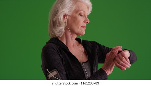 Healthy old woman setting timer on watch before her jog on green screen - Powered by Shutterstock