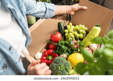 Healthy organic farm grown vegetables and fruits in a delivery cardboard high angle view. - Powered by Shutterstock