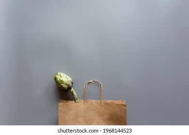 Healthy And Organic Food Flay Lay Concept On Gray Background. Eco Bag With Artichoke.